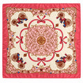 A square silk scarf with a vibrant pink border and a central ornate medallion design in shades of pink, gold, and red, featuring decorative cart motifs in the corners.