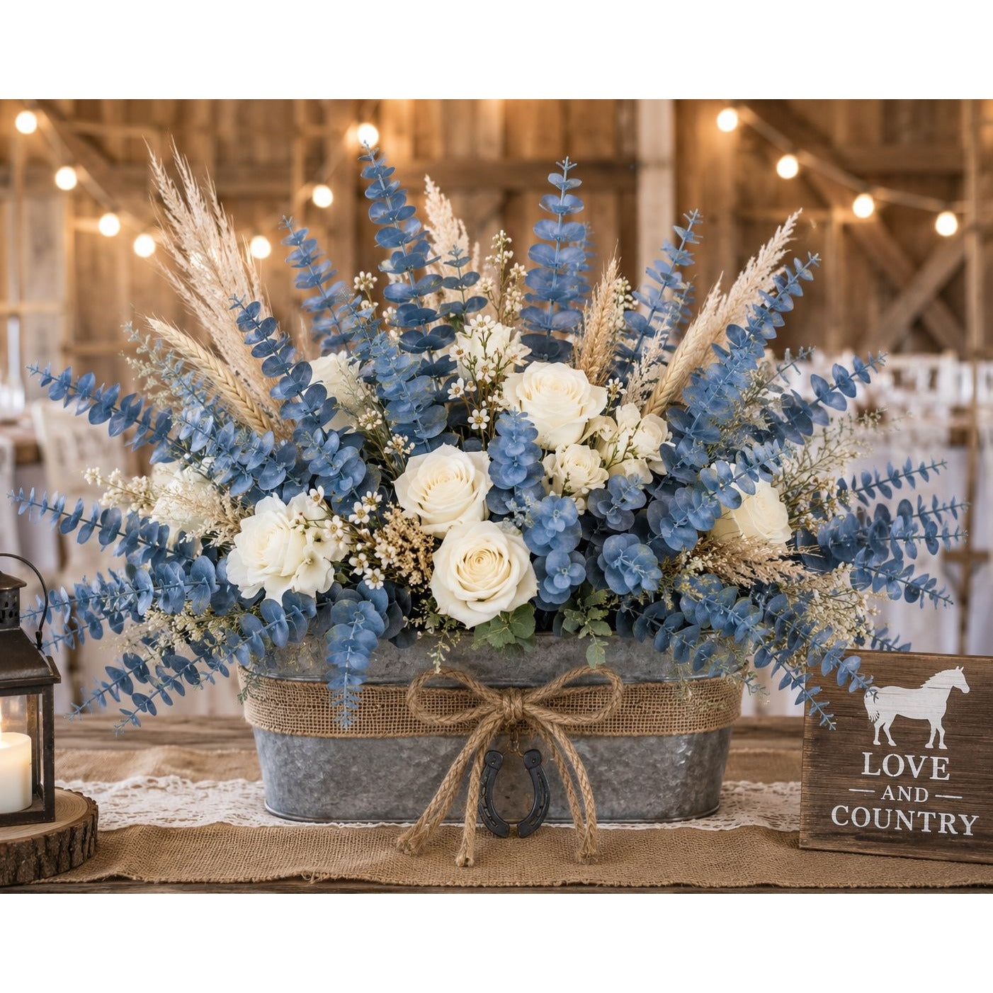 Decorative floral arrangement with blue and white flowers in rustic metal buckets on a table, with 'Love and Country' sign in the background.