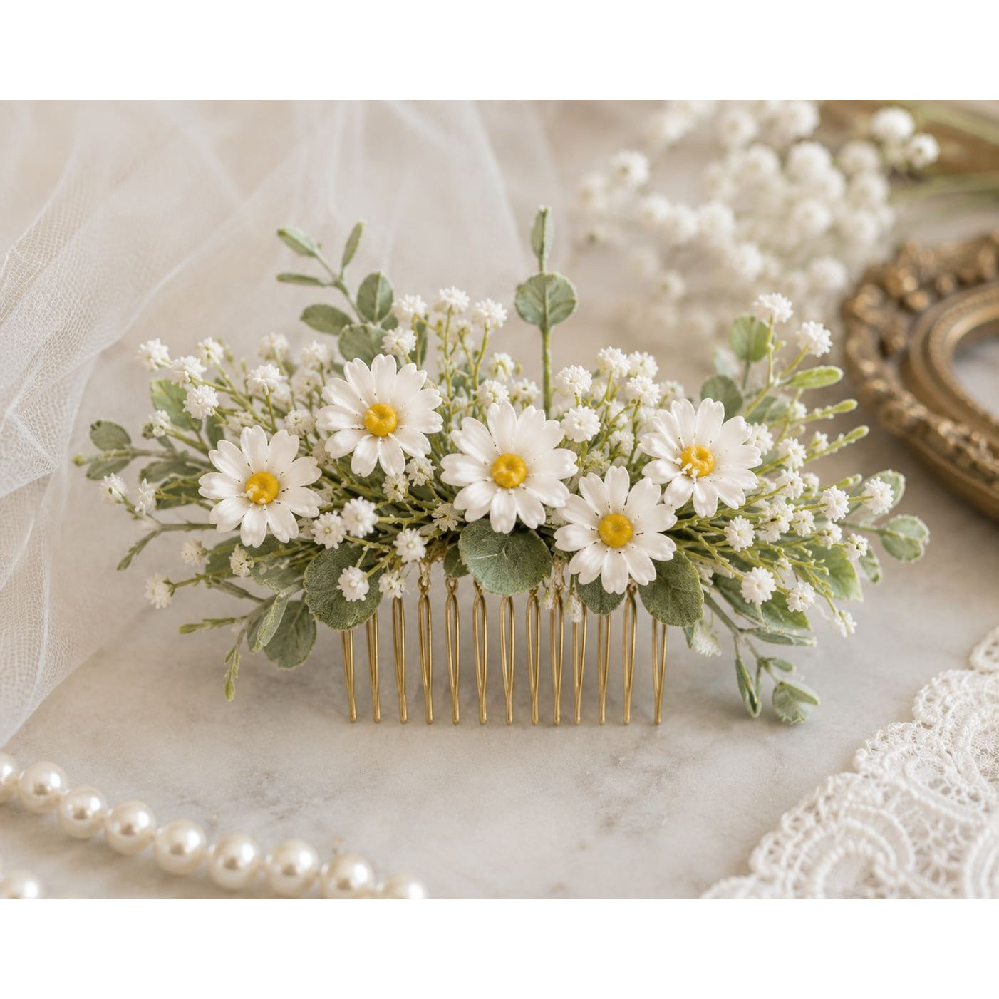 Floral hair comb with white flowers and green leaves on a marble surface.