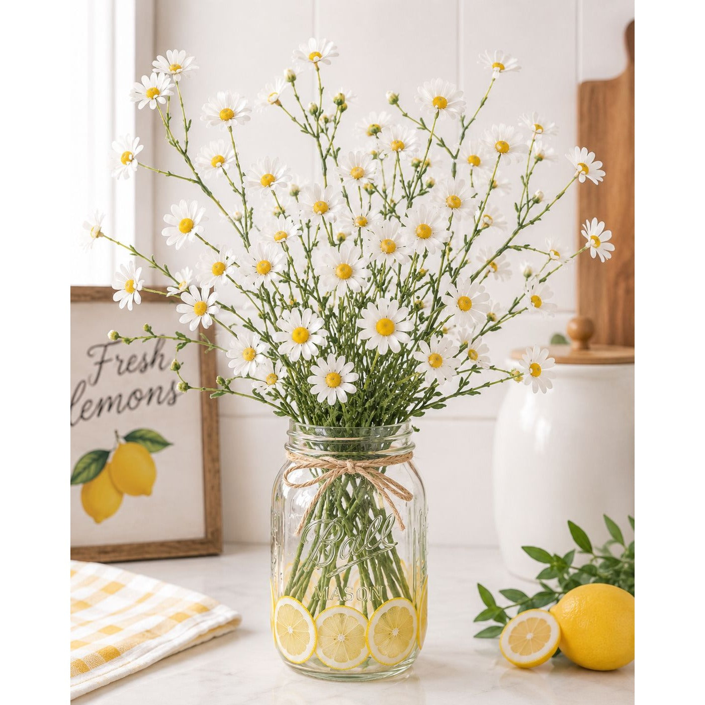 Glass jar with flowers and lemon slices on a table with a decorative sign in the background.