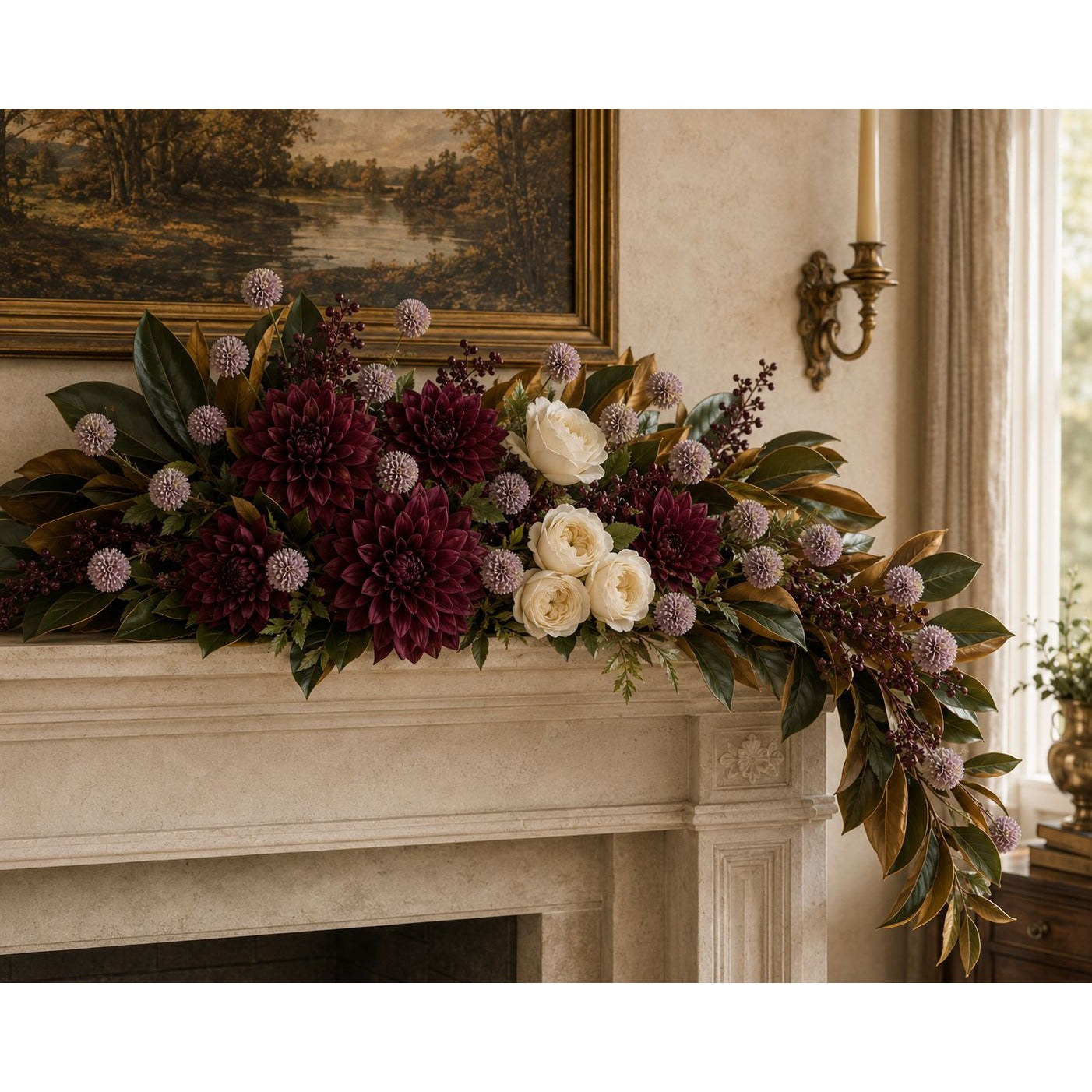 A large floral garland with deep burgundy dahlias, cream roses, green foliage, and purple spiky accents arranged across a stone fireplace mantel in a warm interior setting.