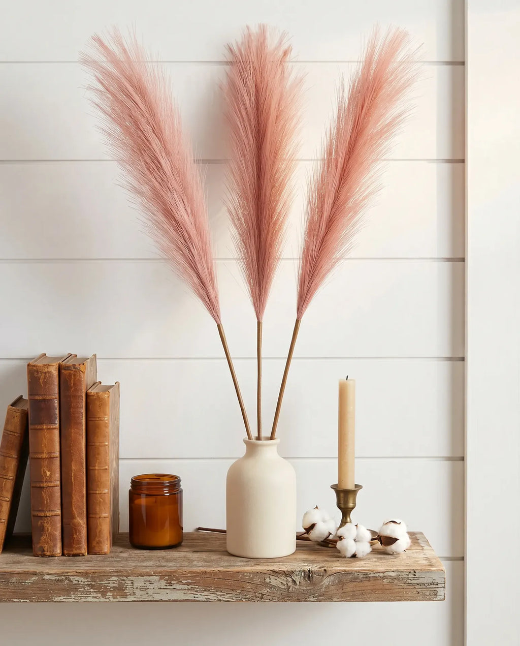 Rose pink faux pampas grass 3 stems on farmhouse wood shelf with shiplap wall, vintage books and cotton stems