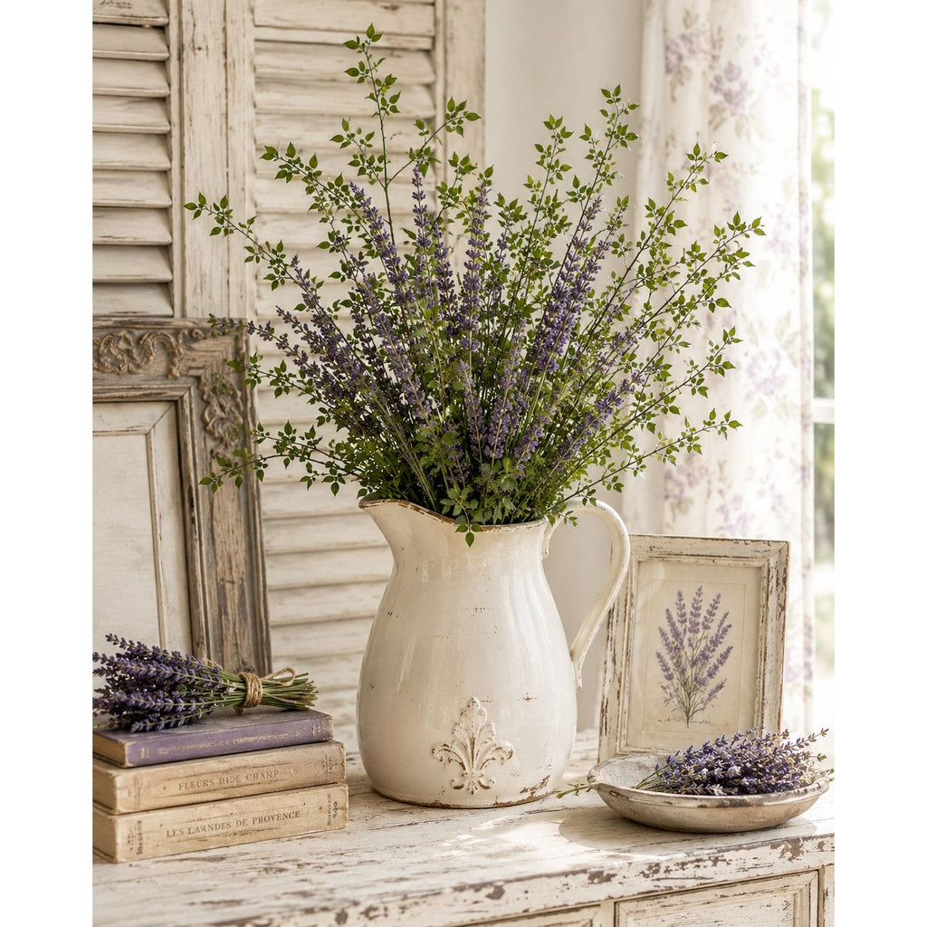 Decorative setting with a pitcher of lavender flowers on a wooden surface.