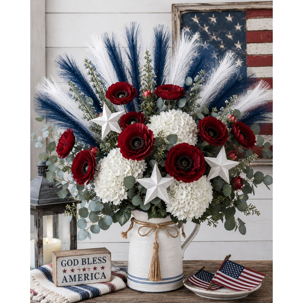 Decorative floral arrangement with red, white, and blue flowers in a white vase, featuring American flags and 'God Bless America' sign.