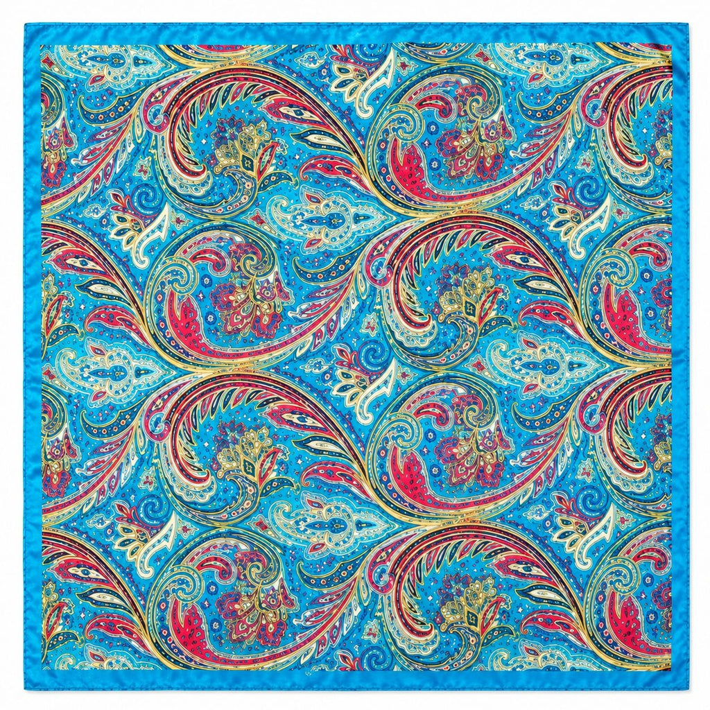 A square scarf with a vibrant blue border and an all-over paisley pattern in red, gold, white, and black on a bright blue background.