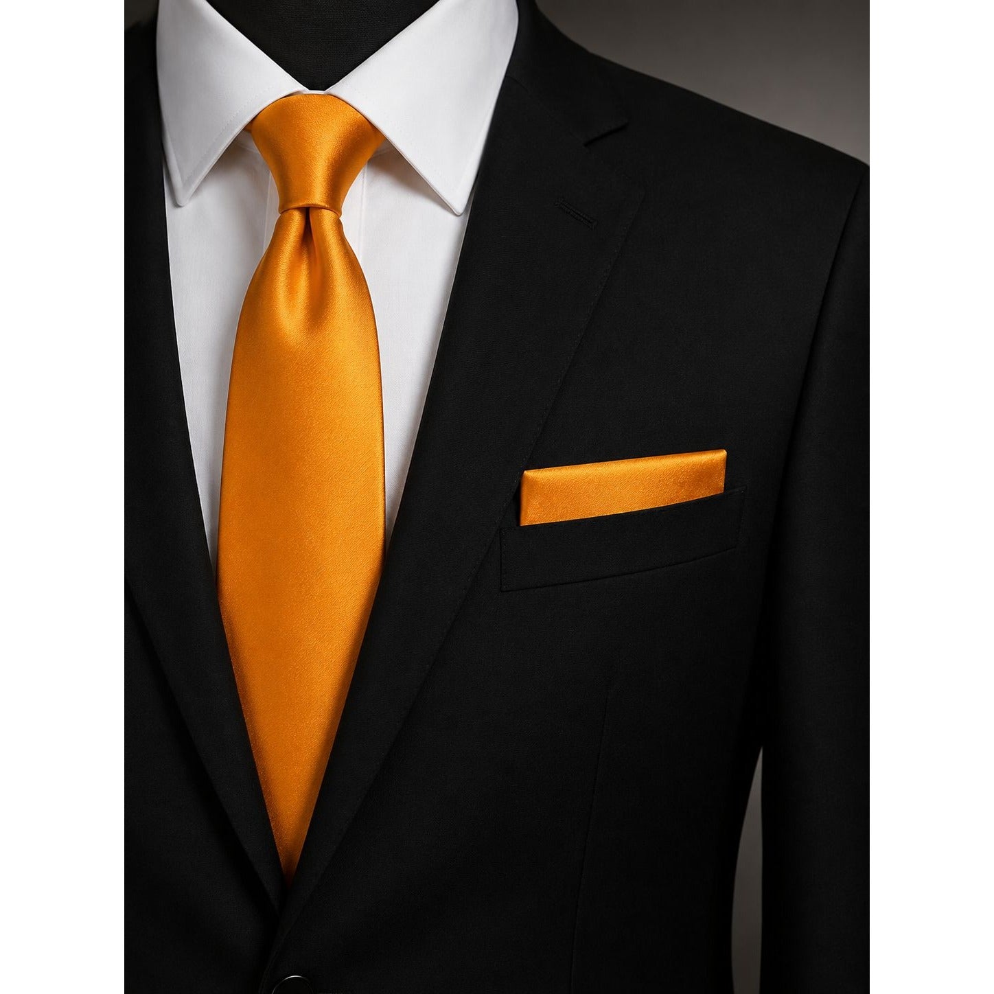 Black suit with a white shirt, gold tie, and matching pocket square.
