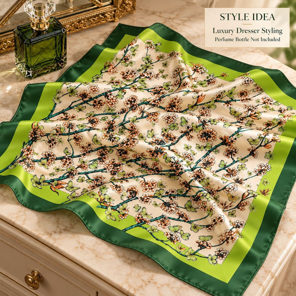 A square silk scarf with a floral branch pattern and green border, styled on a marble vanity surface next to a perfume bottle. Text overlay reads 'STYLE IDEA Luxury Dresser Styling'.
