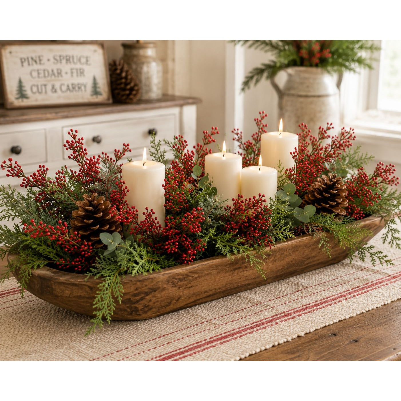 Decorative centerpiece with candles and greenery on a wooden tray in a home setting.
