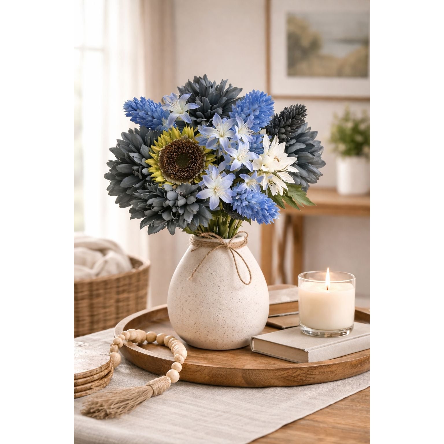 Decorative setting with a vase of flowers on a wooden tray, candle, and books in a home interior.