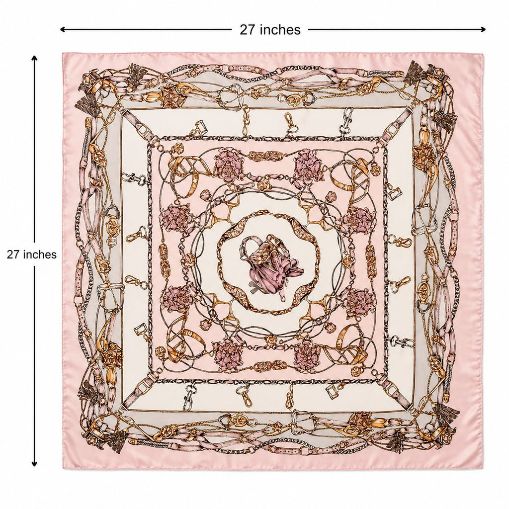 A square pink patterned scarf displayed flat with dimension lines and text indicating 27 inches on each side. The scarf features an ornate chain-link border and a central floral medallion motif in soft pink, beige, and gold tones.