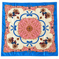 A square silk scarf featuring a vibrant French Chantilly-style pattern with a central pink medallion, blue accents, and pink and gold decorative cartouches with figures.