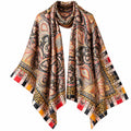 A large square scarf with an intricate paisley and geometric pattern in beige, black, orange, red, and yellow, draped against a plain white background.