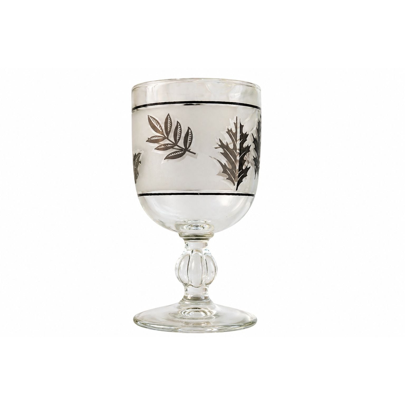 Decorative glass goblet with leaf patterns on a white background