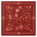 A square red silk scarf featuring an intricate floral pattern in shades of pink and red, finished with a decorative border and double-O logo details in the corners.