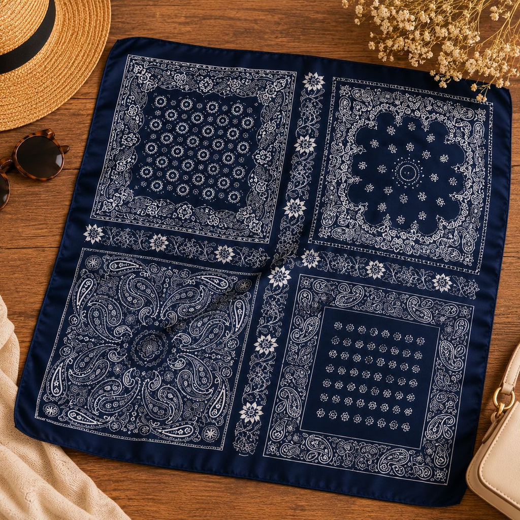 Four navy blue bandanas with white patterns on a wooden surface.