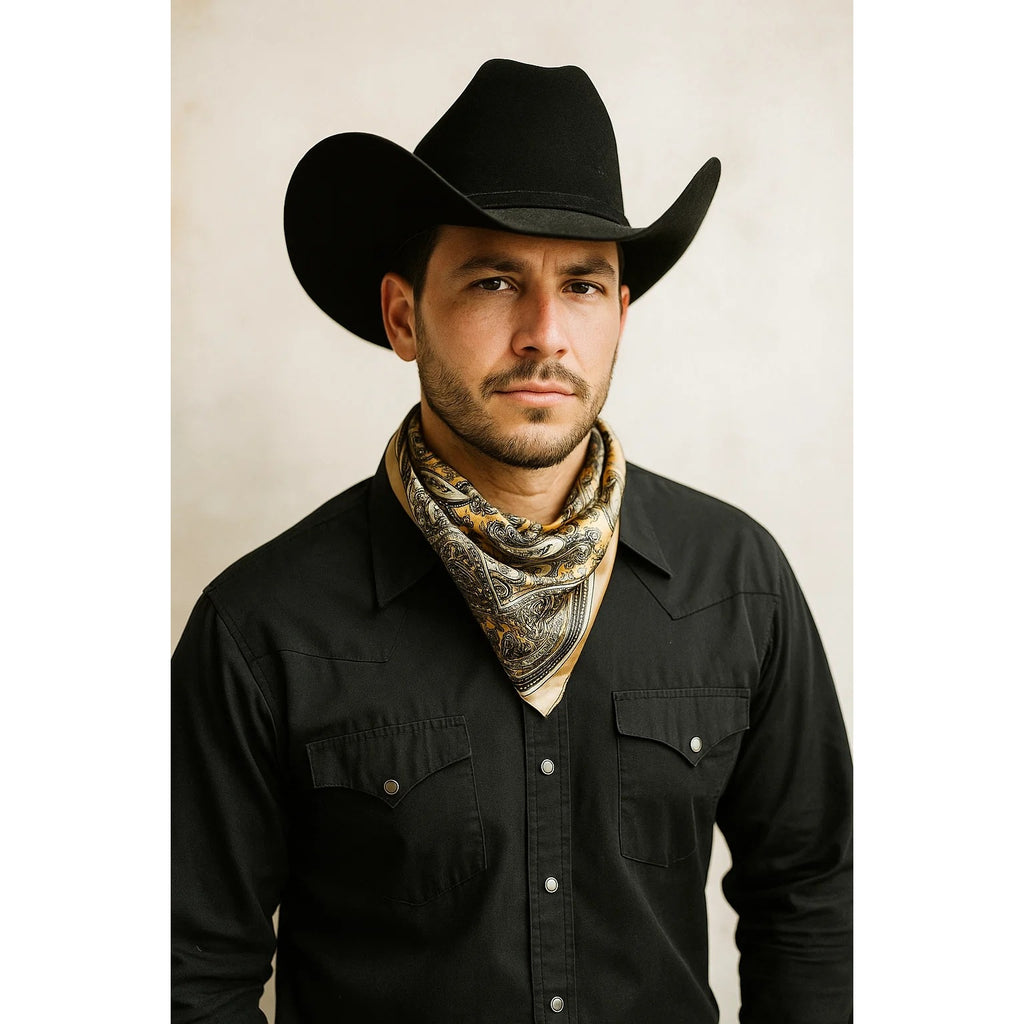 Man wearing a black cowboy hat and black shirt with a patterned bandana around his neck against a beige background