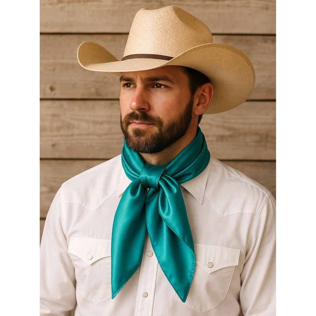 Man wearing a cowboy hat and teal neckerchief against a wooden background