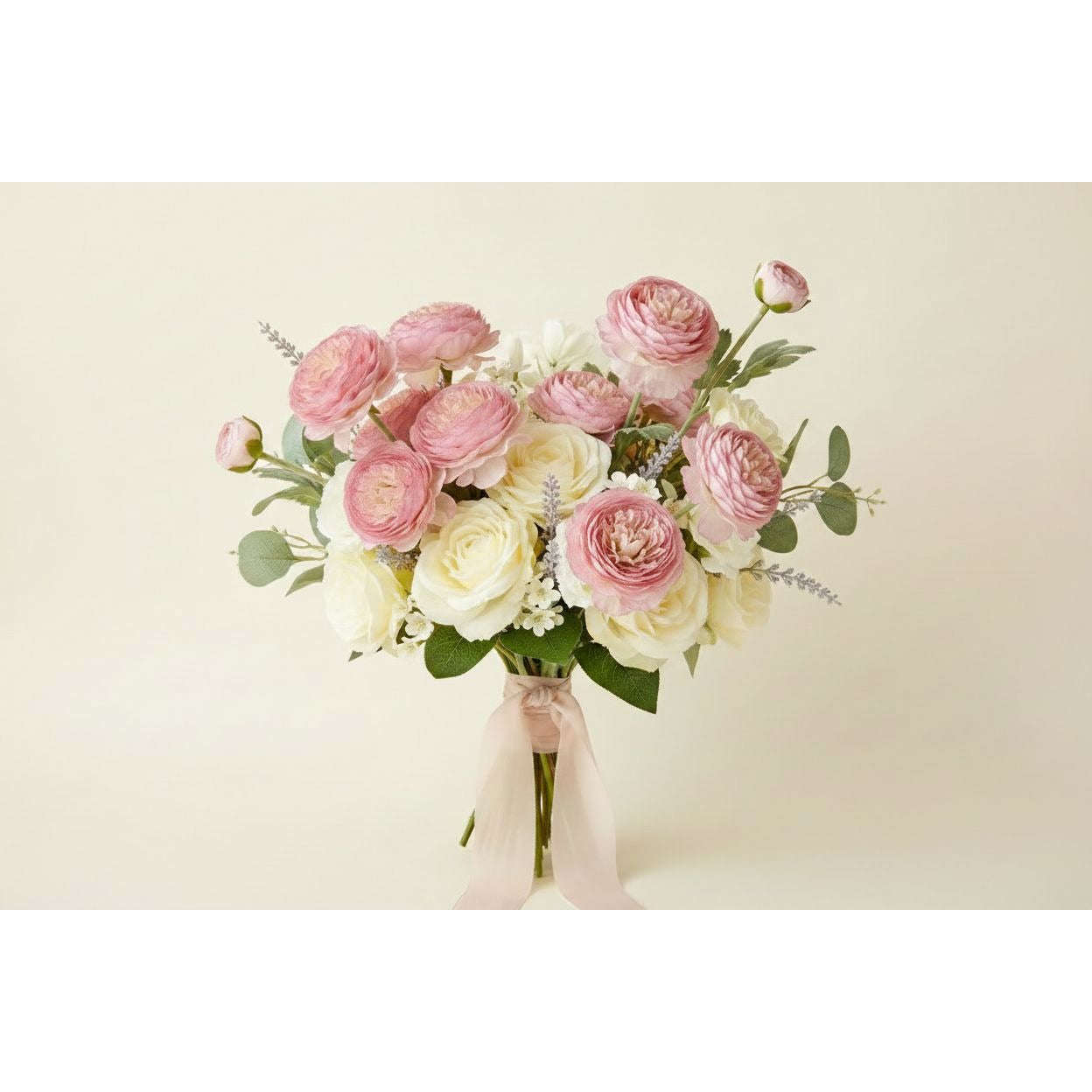 A bouquet of artificial flowers in shades of pink and cream with green foliage, tied with a pale pink ribbon, set against a solid light beige background.