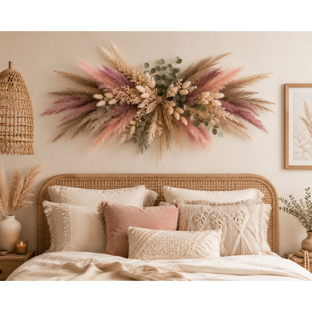 Decorative wall arrangement with dried flowers and plants above a bed in a bedroom.