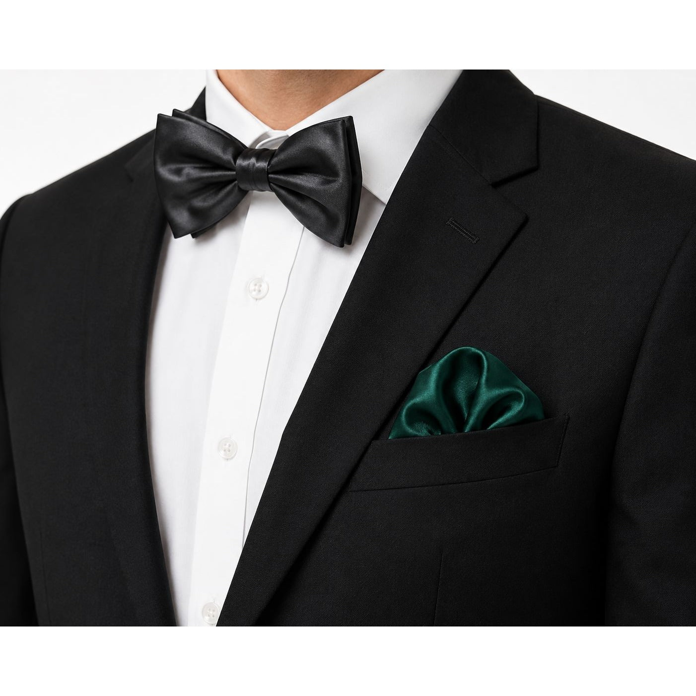Black bow tie and green pocket square on a black suit jacket against a white background