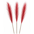 Three artificial red pampas grass stems with brown stems, arranged vertically against a plain white background.