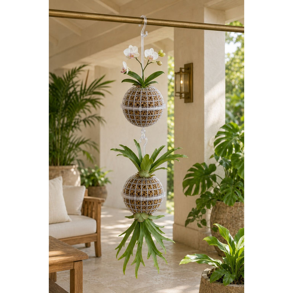 Two hanging woven planters suspended from a metal rod on a porch, each holding a green plant. One planter contains white orchid flowers.