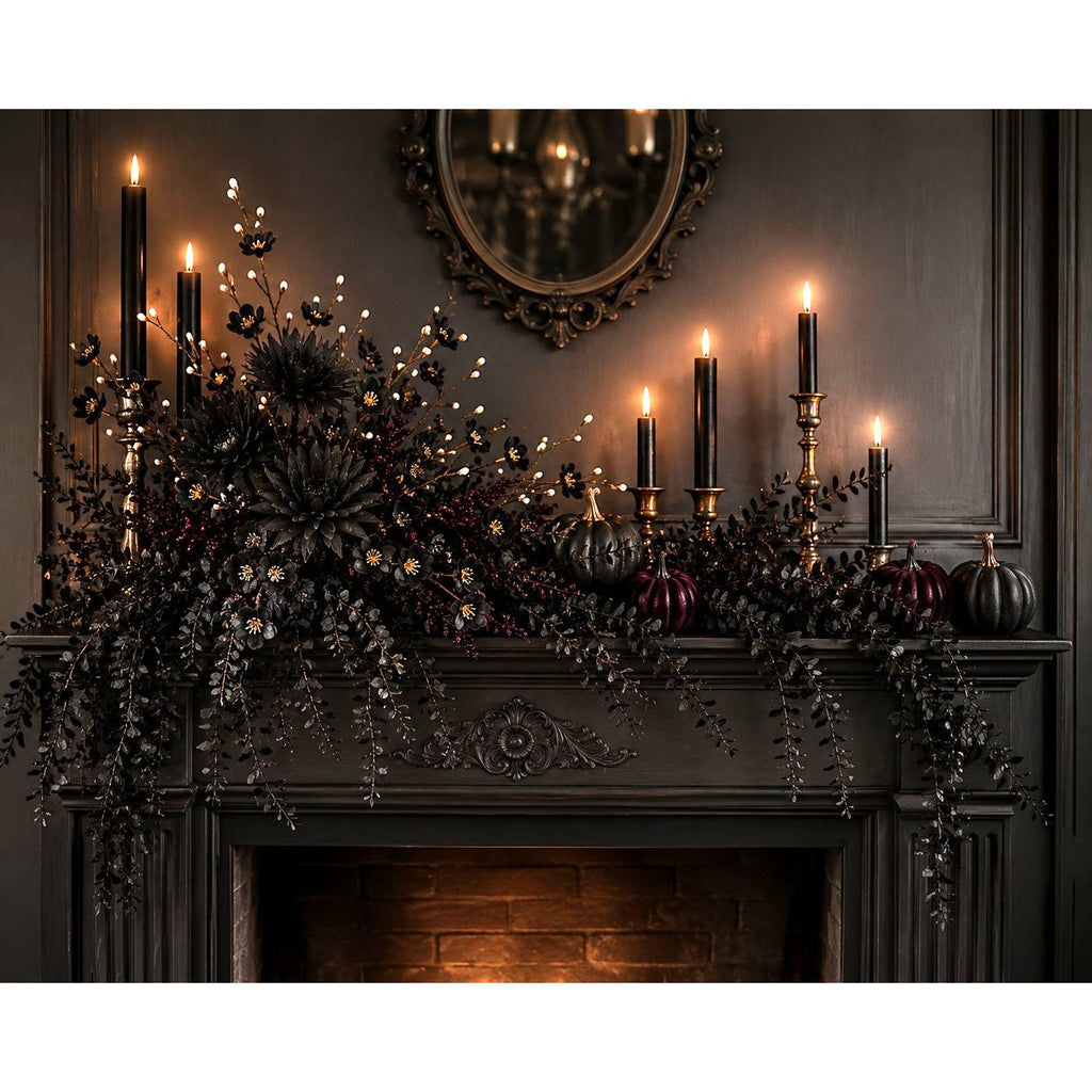 A dark gothic Halloween mantel display featuring black candles, black berries, hanging black foliage, small black pumpkins, and warm white string lights against a dark paneled wall.