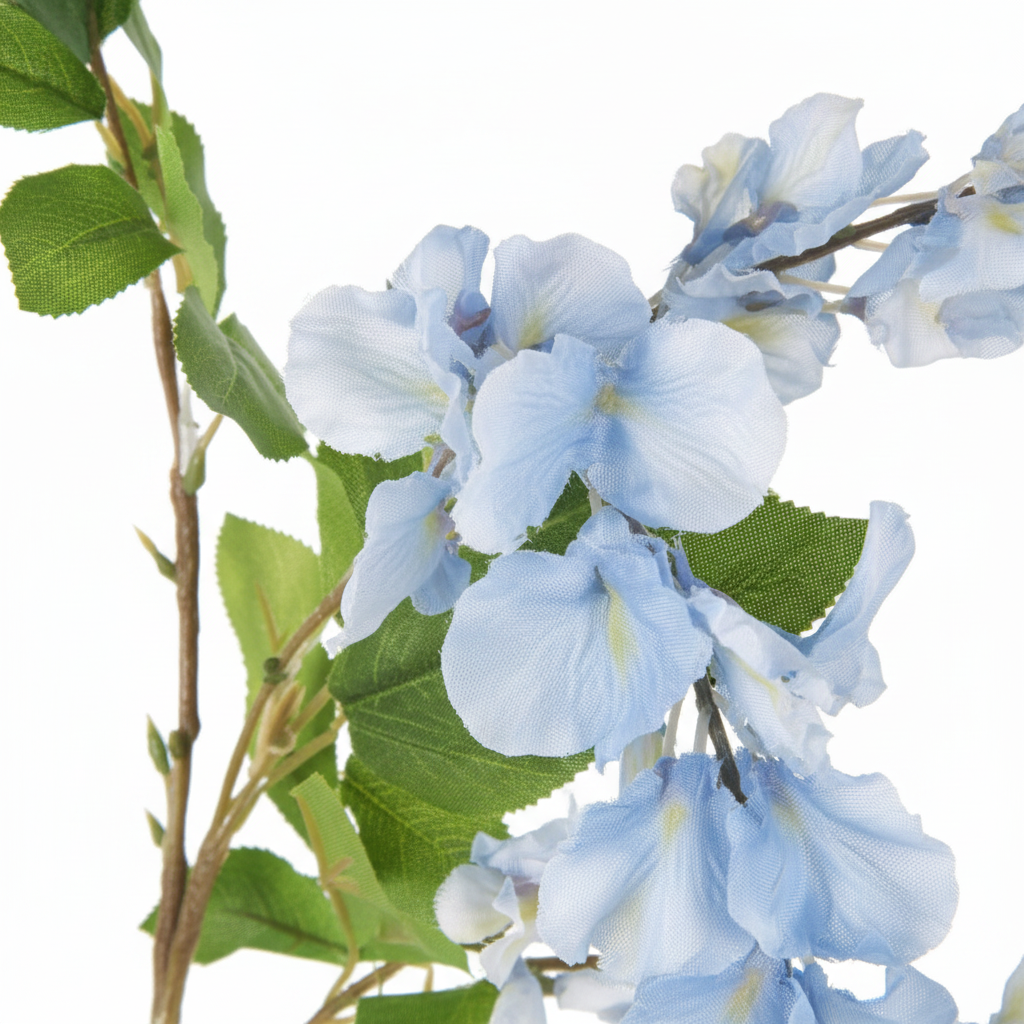 Close-up detail of artificial blue wisteria blooms showing soft blue silk petals with subtle tonal variation and realistic green leaves