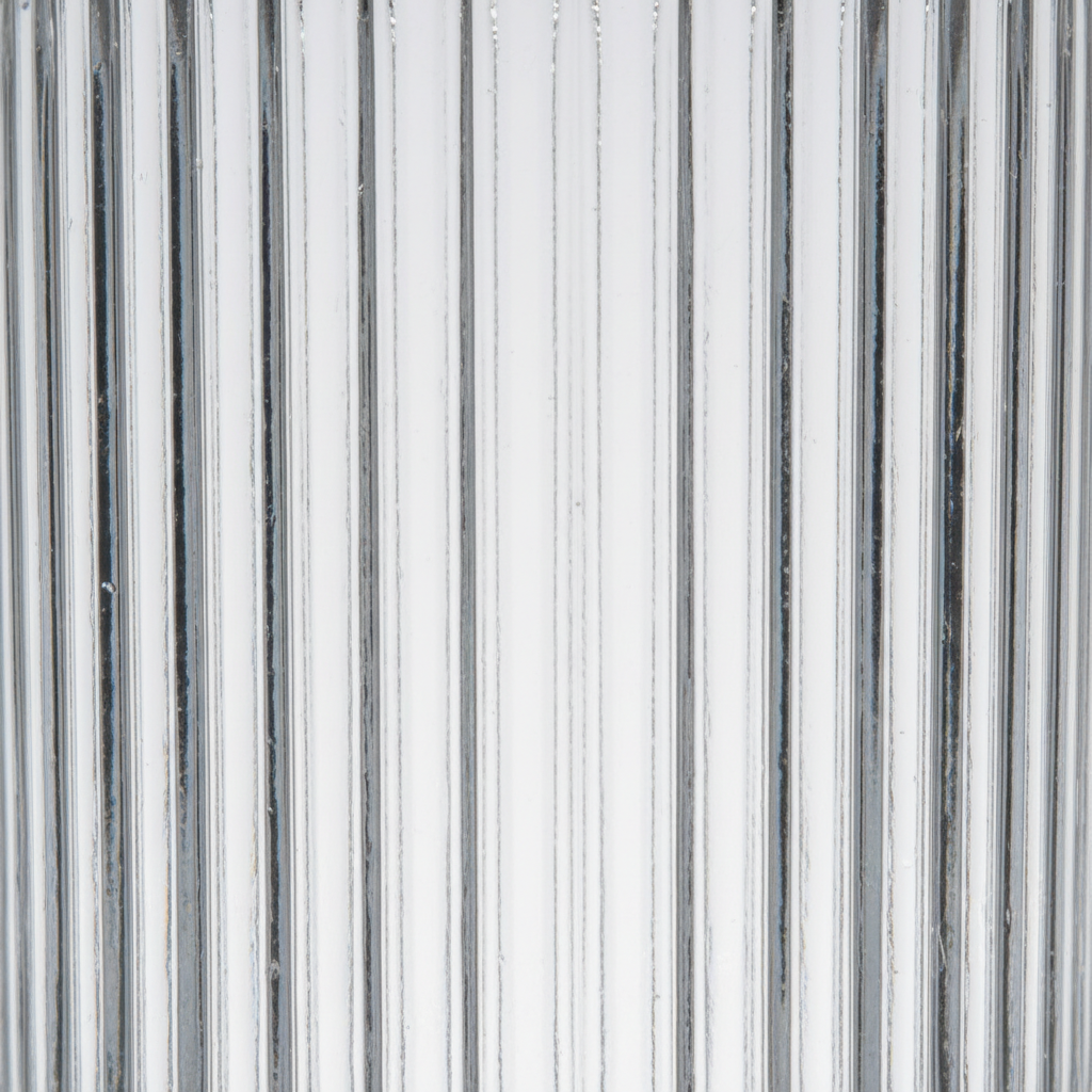 Close-up detail of clear ribbed glass showing vertical prismatic texture and light-diffusing ridges