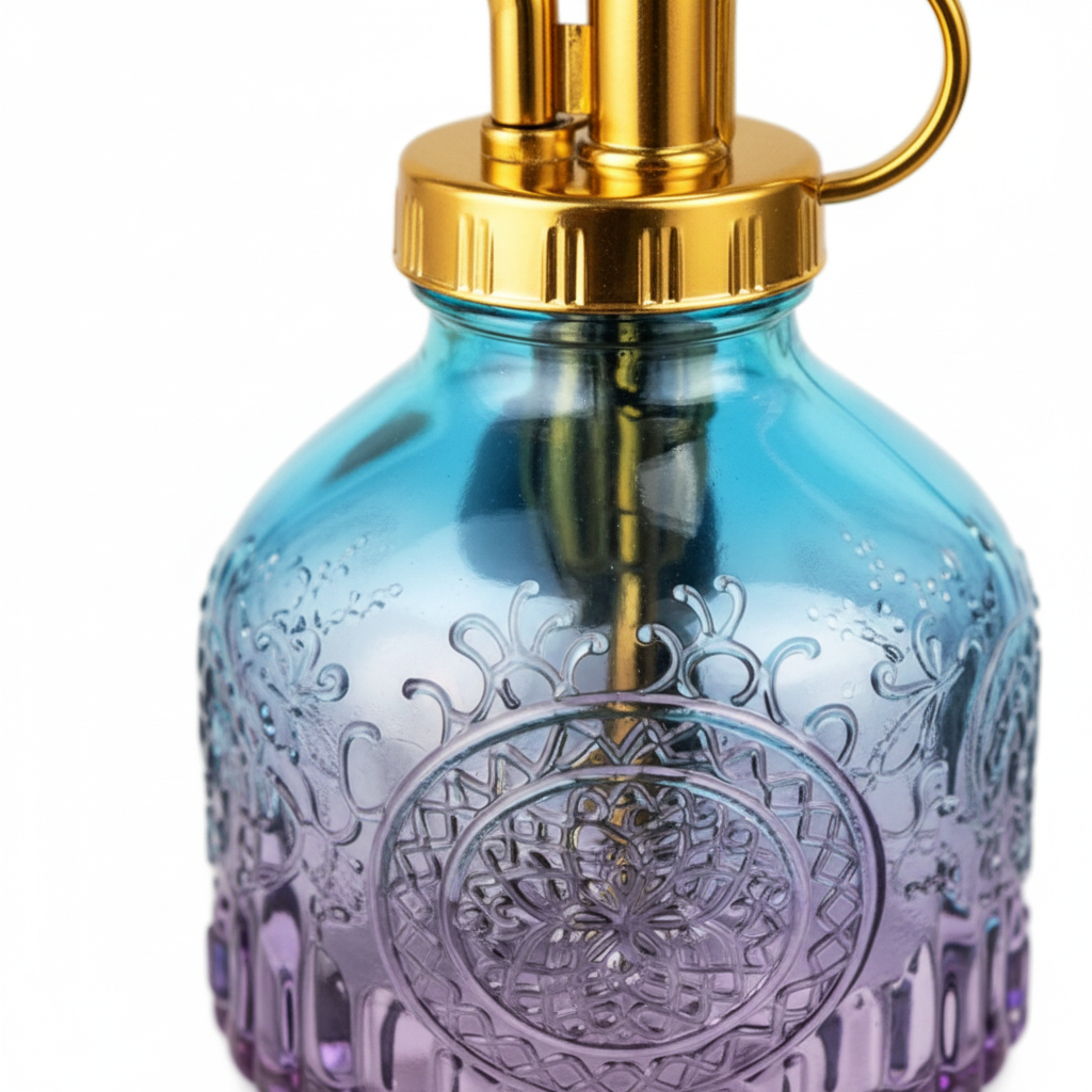 Close-up detail of blue purple gradient textured glass surface with embossed decorative pattern and gold metal spray nozzle tip