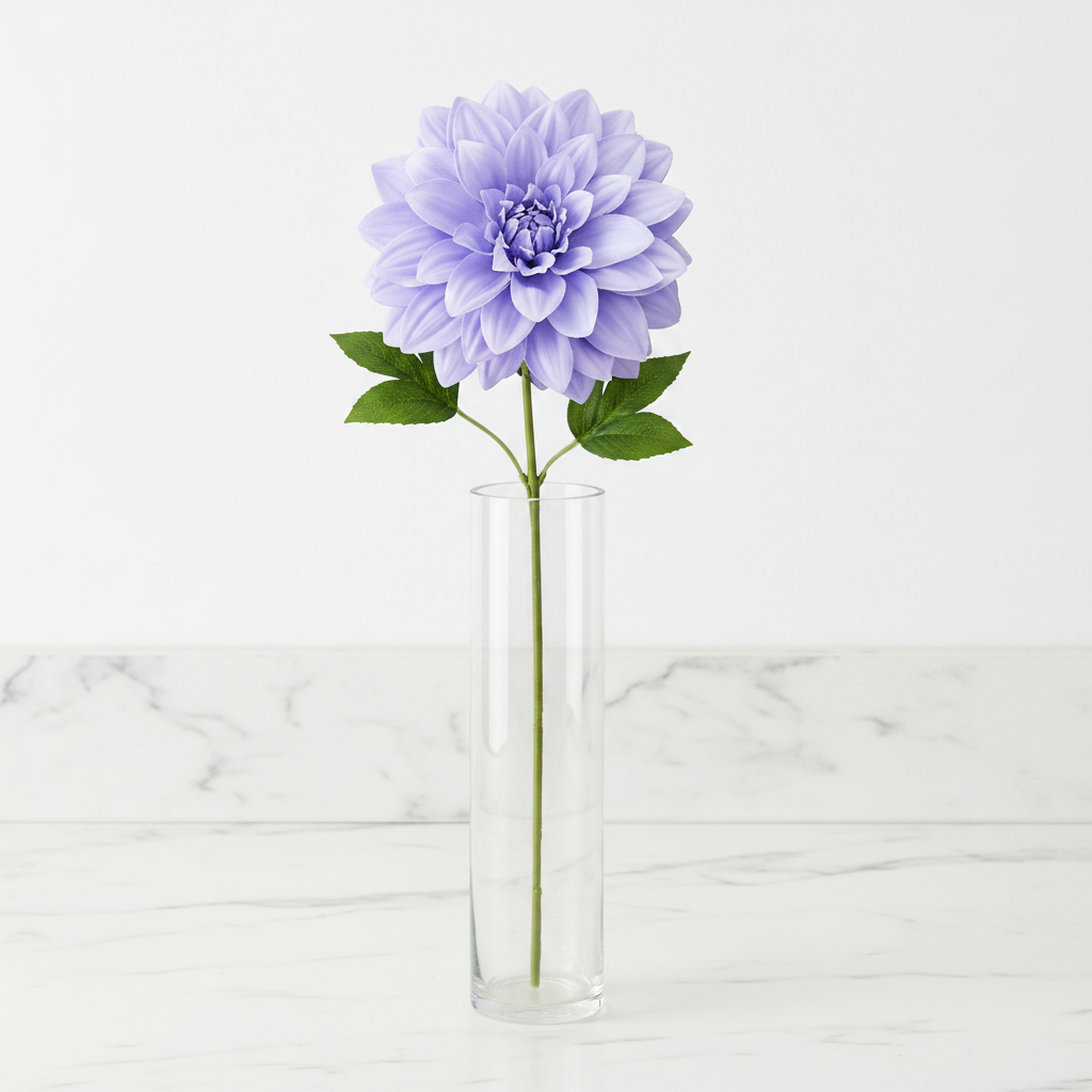 Single periwinkle lavender blue dahlia faux flower stem in tall clear glass vase on white marble countertop