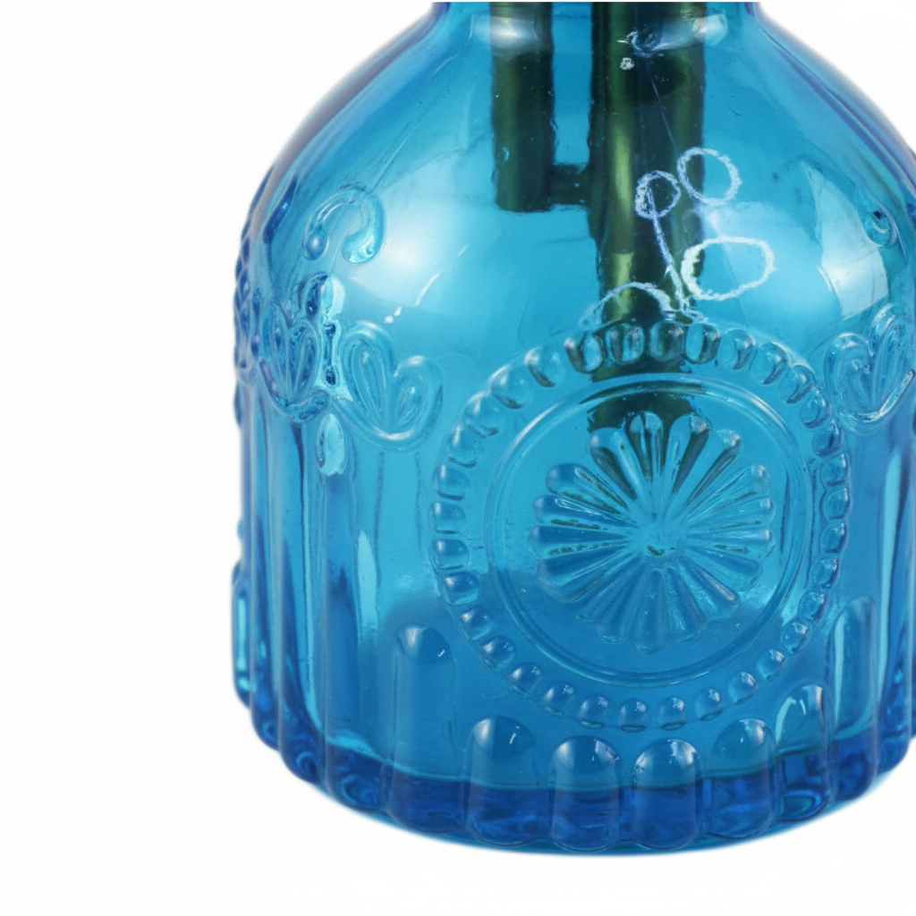Close-up detail of blue ribbed glass texture on plant mister bottle