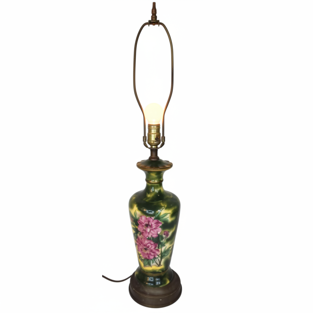 Full view of vintage Victorian ceramic table lamp with exposed glowing bulb, no shade, hand-painted floral design, brass base, white background