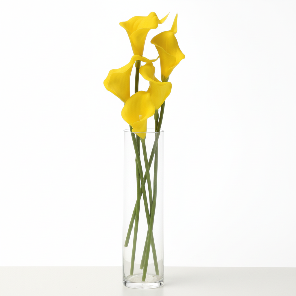 Yellow artificial calla lily stems arranged with greenery in tall glass cylinder vase, modern spring event decor