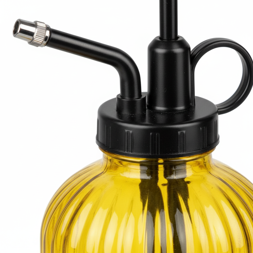 Close-up detail of yellow ribbed glass surface with textured vertical ribs and chrome metal spray nozzle tip