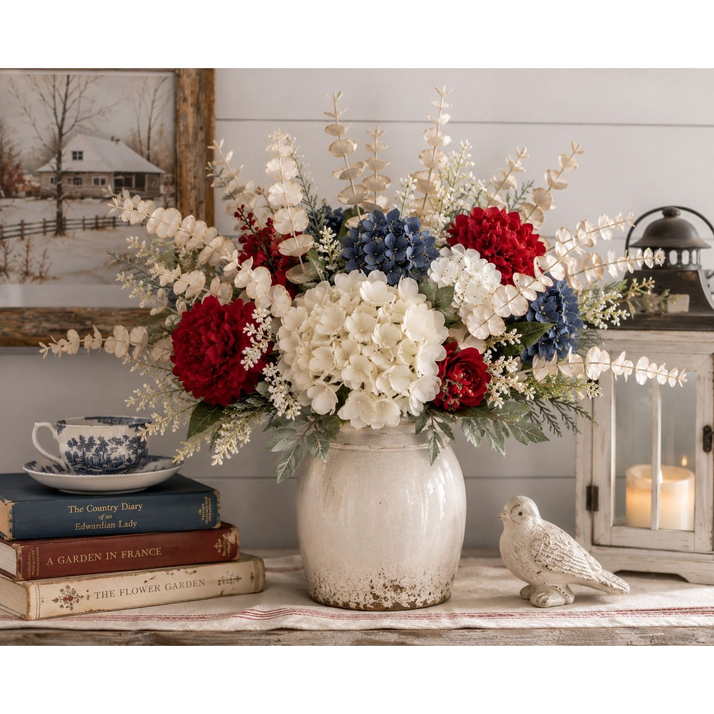 Decorative floral arrangement in a vase on a shelf with books and a bird figurine.