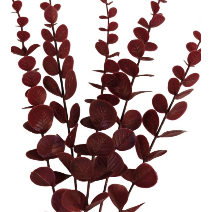 Artificial red eucalyptus branches on a white background