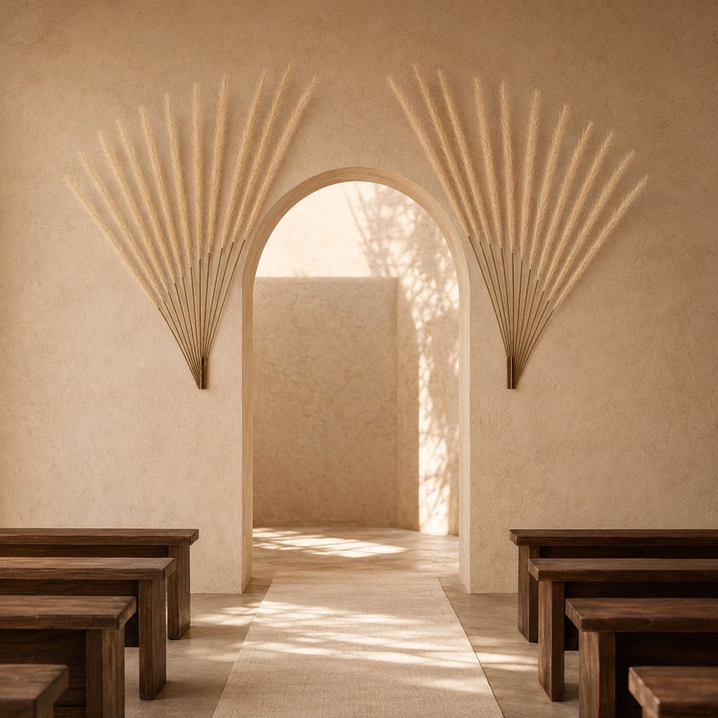 A serene interior scene with a central arched doorway framed by two large sunburst wall sculptures in a warm beige stucco setting. Wooden pews are visible in the foreground, and sunlight streams through leaf shadows onto the floor and walls.
