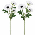 Two artificial anemone flower stems with white petals, dark centers, and green leaves on a plain white background.