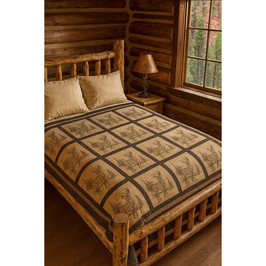 A rustic log bed dressed with a tan quilted comforter featuring a dark brown grid pattern and deer motifs, styled in a cabin bedroom with wood walls and a window.