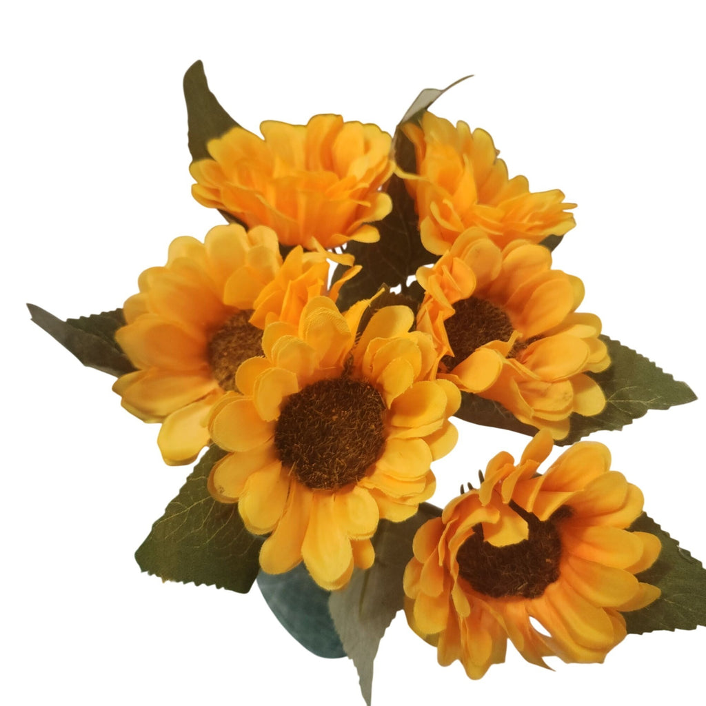 A cluster of artificial yellow sunflowers with dark brown centers and green leaves, isolated on a white background.