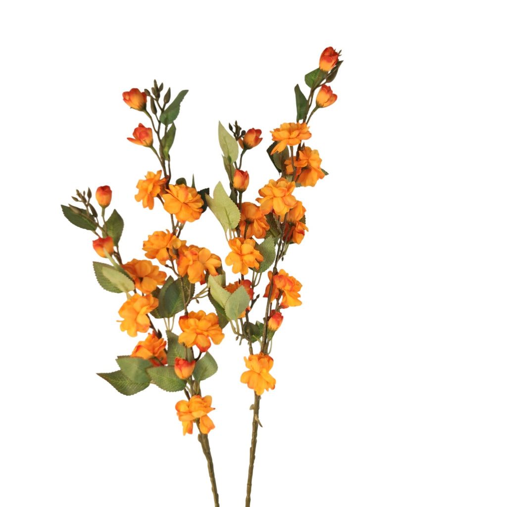 Artificial orange flowers with green leaves and stems, arranged on a plain white background.