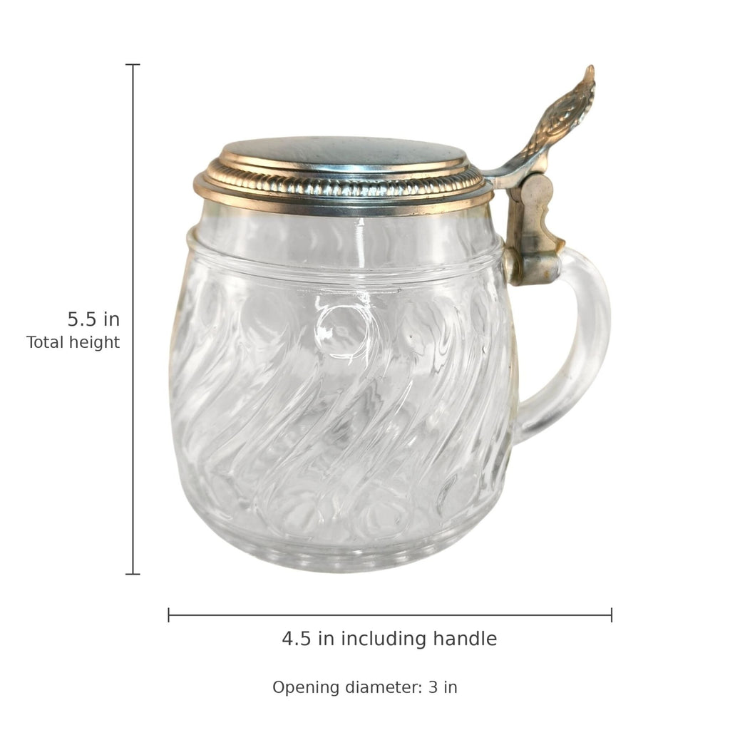 A clear glass mug with a decorative lid and handle, shown with dimension labels indicating a total height of 5.5 inches, width of 4.