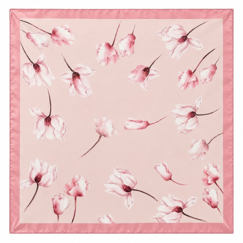 A square pink silk scarf featuring a delicate watercolor print of tulip magnolia in shades of pink and white, finished with a solid pink satin border.