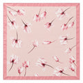 A square pink silk scarf featuring a delicate watercolor print of tulip magnolia in shades of pink and white, finished with a solid pink satin border.